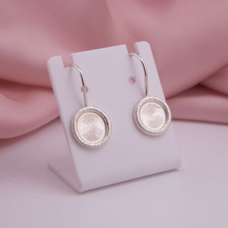 Ein Paar handgefertigte Ohrhänger Coletta aus 925 Sterling Silber mit 12 mm Ronden und fein gefräster, glänzender Struktur auf weißem Hintergrund.